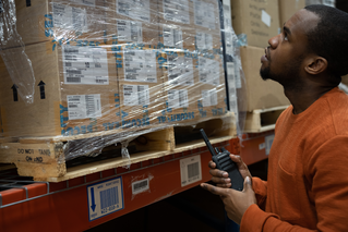 Man with Motorola radio in a warehouse getting two-way radios for sale
