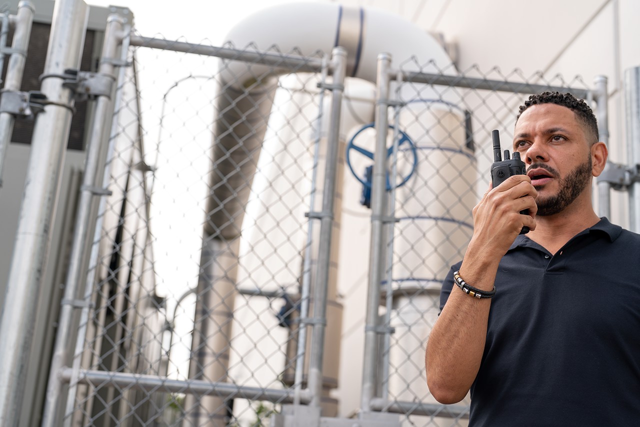 person using Motorola two-way radio on a construction site